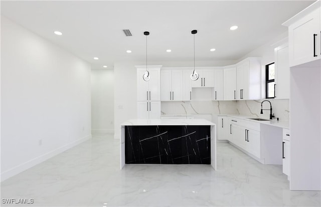 2933 20th St SW, Lehigh Acres, FL 33976 - kitchen featuring light marble finish floors, recessed lighting, pendant lighting, white cabinetry, and backsplash