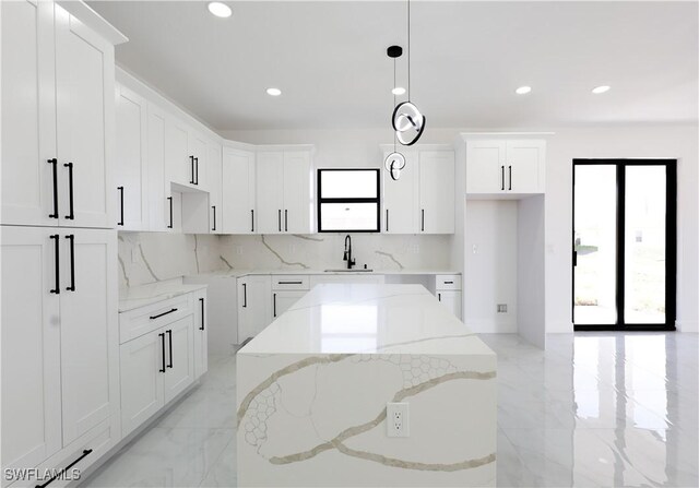 2933 20th St SW, Lehigh Acres, FL 33976 - kitchen with healthy amount of natural light, light marble finish flooring, decorative backsplash, and recessed lighting