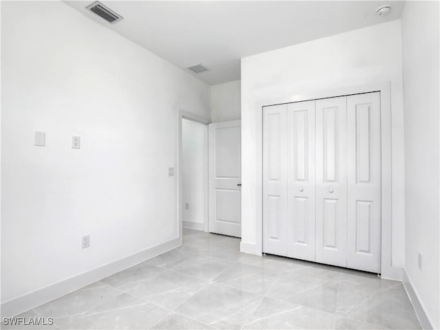 2933 20th St SW, Lehigh Acres, FL 33976 - unfurnished bedroom with a closet and light marble finish floors