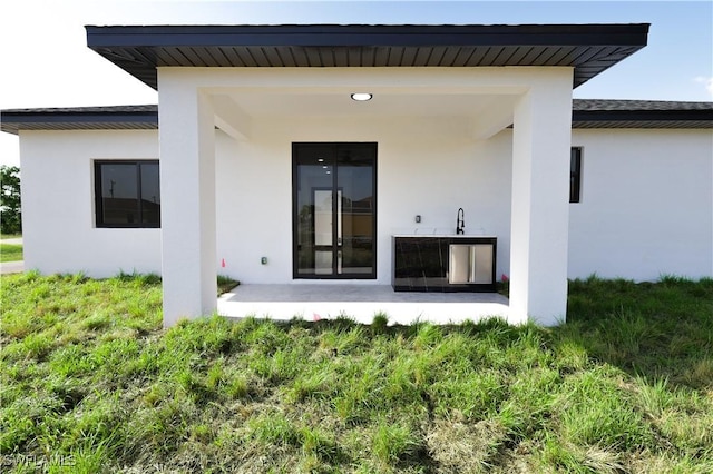 2933 20th St SW, Lehigh Acres, FL 33976 - back of property featuring stucco siding and a patio