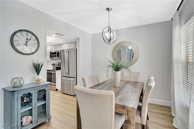 773 Wiggins Lake Dr Unit 101, Naples, FL 34110 - dining area featuring light wood finished floors, a chandelier, and baseboards
