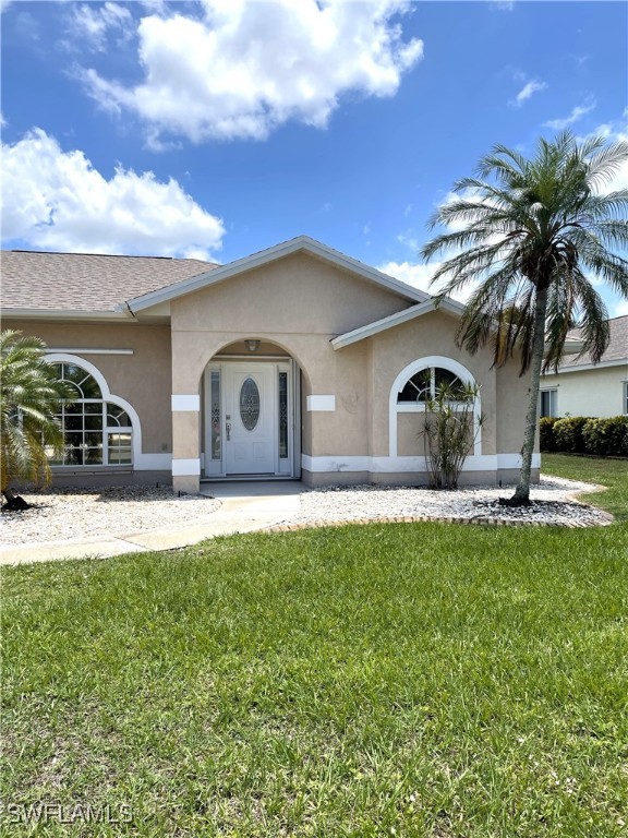 86 Pinehurst Pl, Rotonda West, FL 33947 - view of front of property featuring stucco siding and a front yard