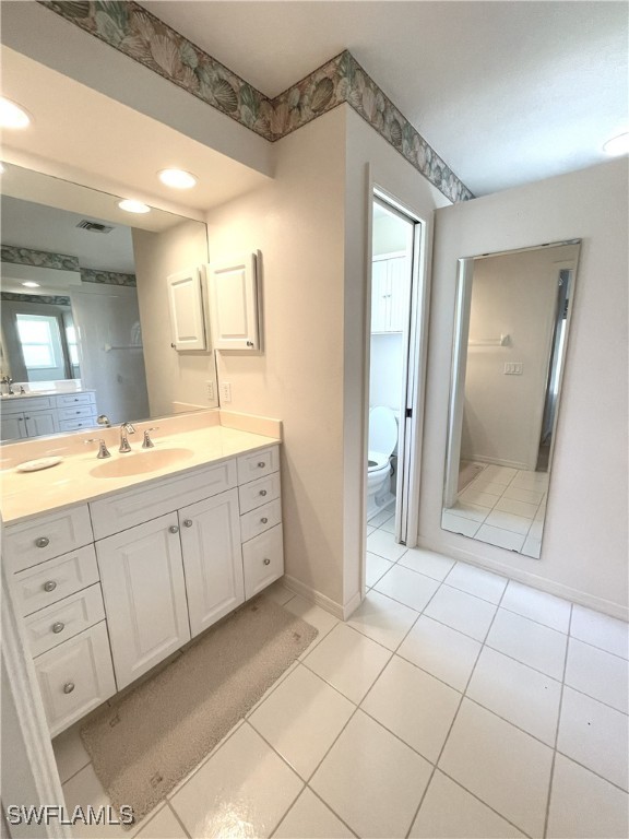 86 Pinehurst Pl, Rotonda West, FL 33947 - bathroom with vanity, toilet, tile patterned flooring, and baseboards
