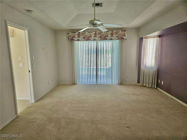 86 Pinehurst Pl, Rotonda West, FL 33947 - spare room featuring a ceiling fan, light carpet, plenty of natural light, and a tray ceiling