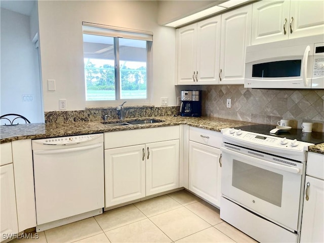 86 Pinehurst Pl, Rotonda West, FL 33947 - kitchen featuring white appliances, dark stone counters, light tile patterned flooring, backsplash, and white cabinetry