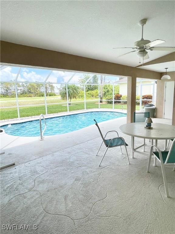 86 Pinehurst Pl, Rotonda West, FL 33947 - swimming pool with ceiling fan, a patio, glass enclosure, and a lawn