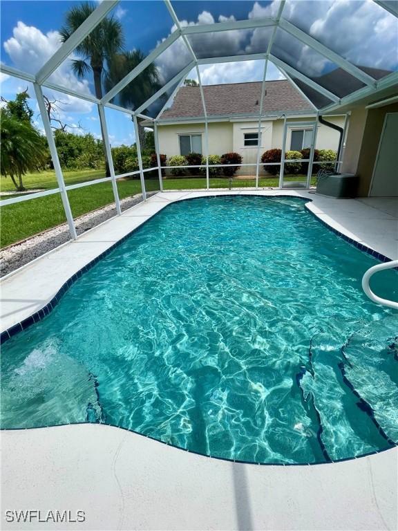86 Pinehurst Pl, Rotonda West, FL 33947 - swimming pool featuring a patio area, glass enclosure, and a lawn