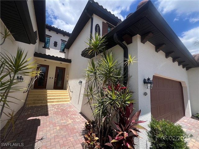 12048 Hawthorn Lake Dr Unit 202, Fort Myers, FL 33913 - view of exterior entry with stucco siding and an attached garage