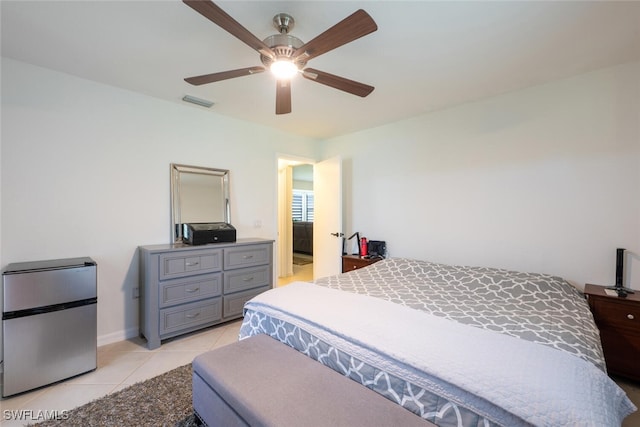 725 Grove Dr, Naples, FL 34120 - bedroom with freestanding refrigerator, light tile patterned floors, and a ceiling fan