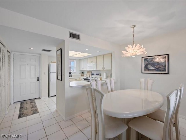 897 Collier Ct Unit 4-705, Marco Island, FL 34145 - dining area with a chandelier, light tile patterned flooring, and baseboards