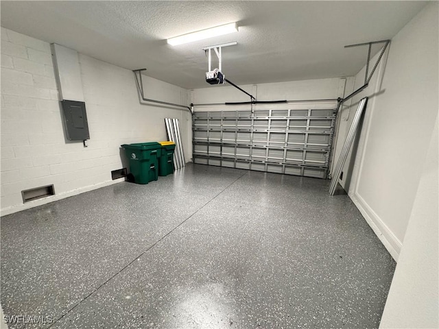 garage featuring a garage door opener, electric panel, and concrete block wall