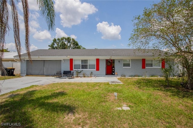 221 Paine Dr, Winter Haven, FL 33884 - single story home with brick siding, a front yard, an attached garage, and concrete driveway