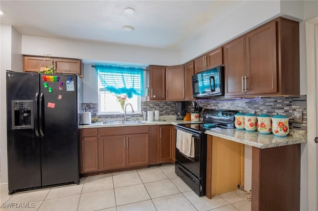 221 Paine Dr, Winter Haven, FL 33884 - kitchen with black appliances, a sink, light tile patterned floors, tasteful backsplash, and brown cabinetry