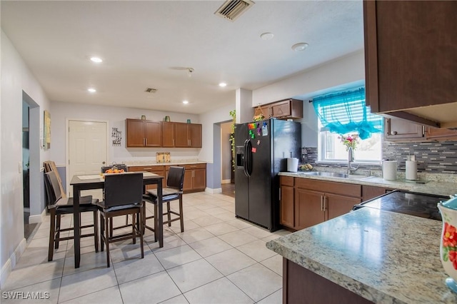 221 Paine Dr, Winter Haven, FL 33884 - kitchen featuring a sink, tasteful backsplash, black fridge with ice dispenser, baseboards, and recessed lighting