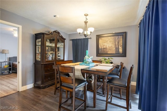 221 Paine Dr, Winter Haven, FL 33884 - dining area with a chandelier, dark wood-style flooring, and baseboards