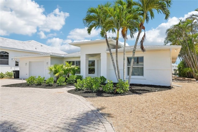 18195 Cutlass Dr, Fort Myers Beach, FL 33931 - view of front of property with an attached garage, decorative driveway, and stucco siding