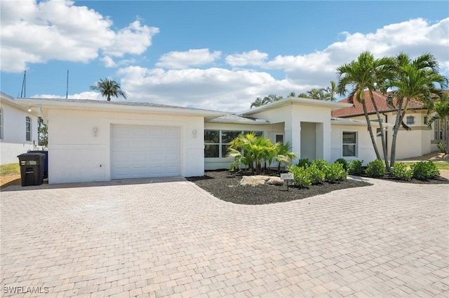18195 Cutlass Dr, Fort Myers Beach, FL 33931 - view of front of home with an attached garage, decorative driveway, and stucco siding