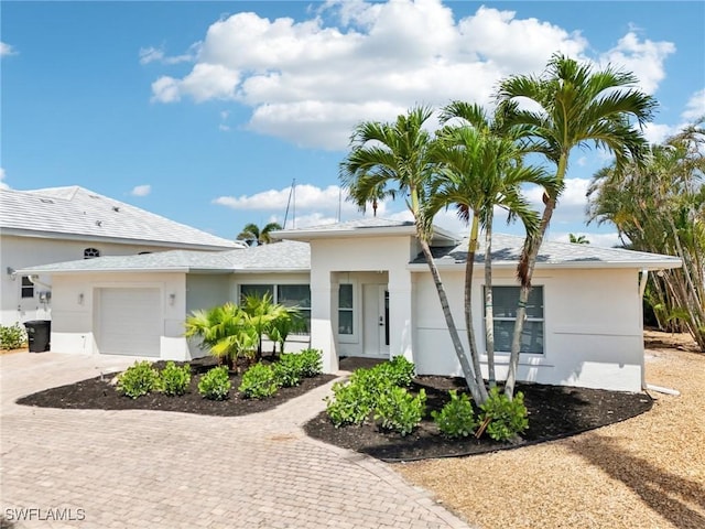 18195 Cutlass Dr, Fort Myers Beach, FL 33931 - ranch-style house featuring decorative driveway, an attached garage, and stucco siding