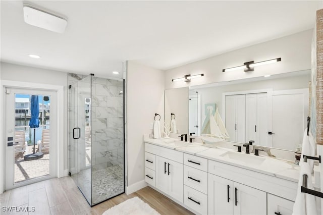 18195 Cutlass Dr, Fort Myers Beach, FL 33931 - bathroom with a shower stall, recessed lighting, double vanity, wood finished floors, and baseboards