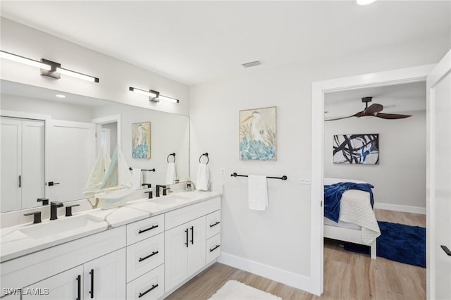 18195 Cutlass Dr, Fort Myers Beach, FL 33931 - ensuite bathroom with baseboards, wood finished floors, double vanity, and a ceiling fan