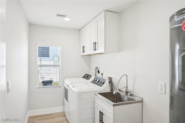 18195 Cutlass Dr, Fort Myers Beach, FL 33931 - washroom with washing machine and dryer, light wood-type flooring, cabinet space, and baseboards
