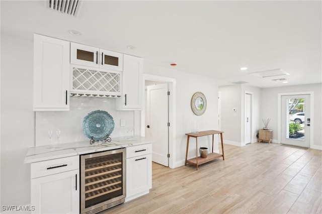 18195 Cutlass Dr, Fort Myers Beach, FL 33931 - indoor dry bar with beverage cooler, baseboards, light wood finished floors, decorative backsplash, and recessed lighting