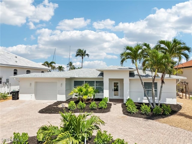 18195 Cutlass Dr, Fort Myers Beach, FL 33931 - view of front of house with decorative driveway, a garage, and stucco siding