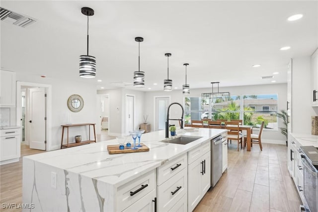 18195 Cutlass Dr, Fort Myers Beach, FL 33931 - kitchen featuring a sink, a center island with sink, white cabinets, recessed lighting, and stainless steel appliances