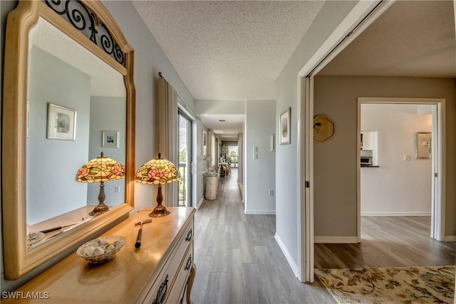 6979 Winkler Rd Unit 131, Fort Myers, FL 33919 - corridor with wood finished floors, a textured ceiling, and baseboards