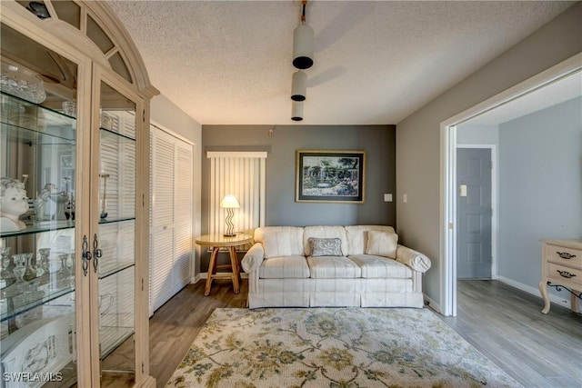 6979 Winkler Rd Unit 131, Fort Myers, FL 33919 - living area featuring wood finished floors, baseboards, a textured ceiling, and french doors
