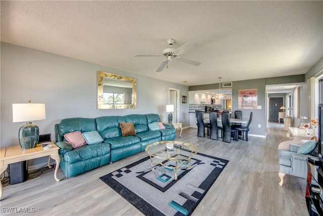 6979 Winkler Rd Unit 131, Fort Myers, FL 33919 - living area featuring light wood-type flooring, a textured ceiling, a ceiling fan, and baseboards