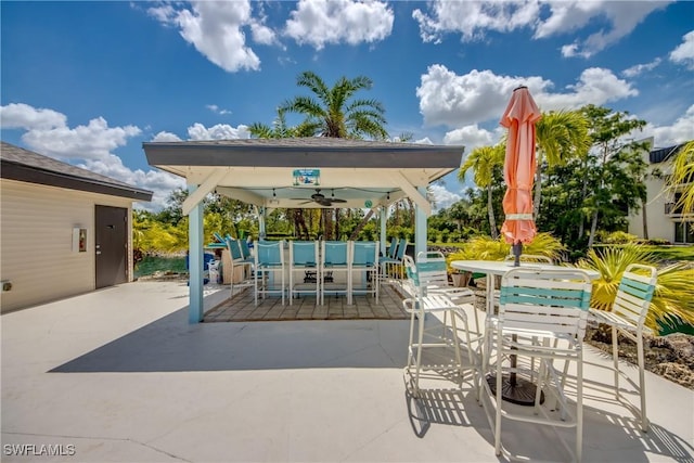 6979 Winkler Rd Unit 131, Fort Myers, FL 33919 - view of patio / terrace with a gazebo, outdoor dining space, ceiling fan, and a bar