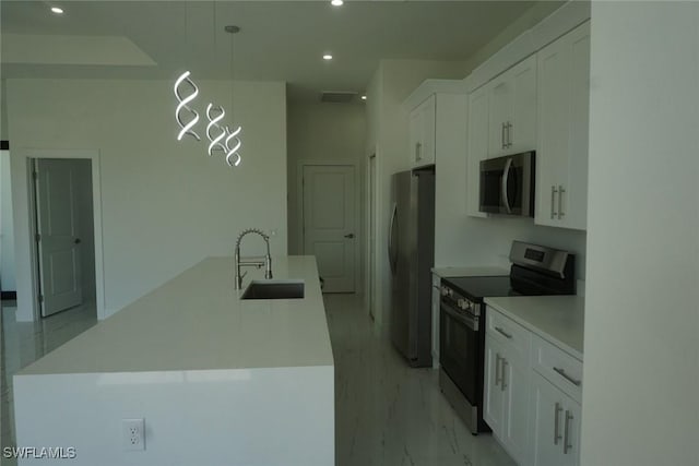 826 Alido Ave, Lehigh Acres, FL 33971 - kitchen with appliances with stainless steel finishes, a sink, recessed lighting, white cabinetry, and a kitchen island with sink