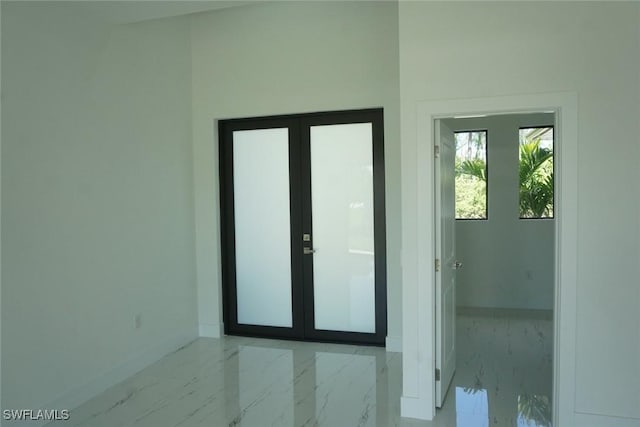 826 Alido Ave, Lehigh Acres, FL 33971 - empty room featuring marble tiled floors, baseboards, and french doors