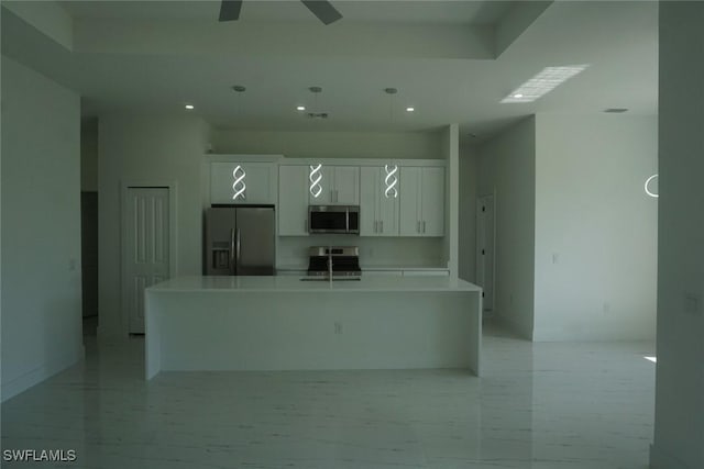 826 Alido Ave, Lehigh Acres, FL 33971 - kitchen with stainless steel appliances, a spacious island, white cabinetry, recessed lighting, and light countertops