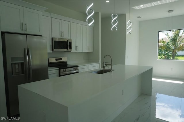 826 Alido Ave, Lehigh Acres, FL 33971 - kitchen with stainless steel appliances, light marble finish flooring, a sink, white cabinetry, and a kitchen island with sink