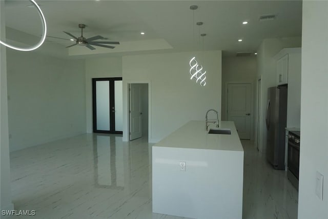 826 Alido Ave, Lehigh Acres, FL 33971 - kitchen with a sink, freestanding refrigerator, white cabinets, ceiling fan, and a center island with sink