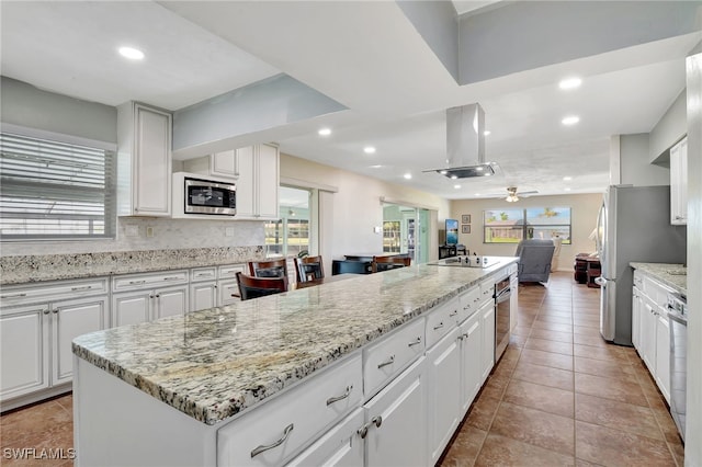 250 Bangsberg Rd SE, Port Charlotte, FL 33952 - kitchen featuring appliances with stainless steel finishes, island exhaust hood, recessed lighting, open floor plan, and white cabinets