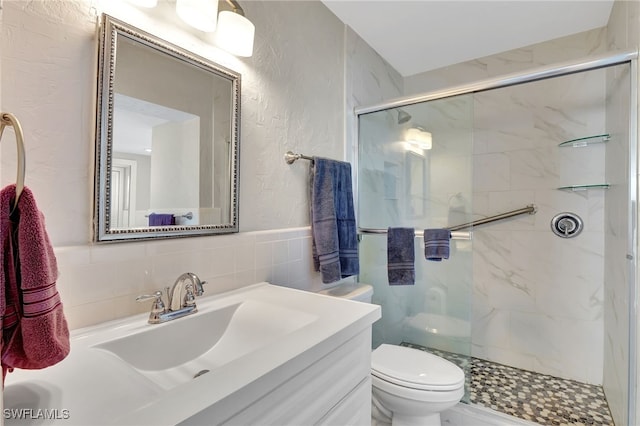 250 Bangsberg Rd SE, Port Charlotte, FL 33952 - bathroom featuring a marble finish shower, toilet, a textured wall, vanity, and tile walls