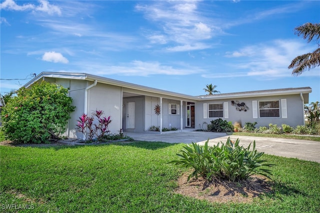 250 Bangsberg Rd SE, Port Charlotte, FL 33952 - view of front of house featuring a front lawn, concrete driveway, and stucco siding