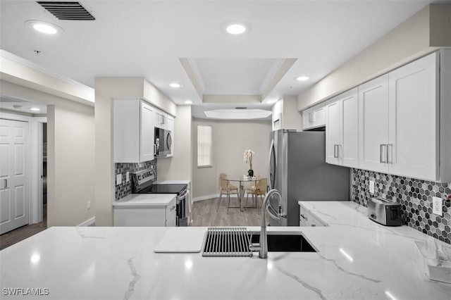 1793 Four Mile Cove Pkwy Unit 723, Cape Coral, FL 33990 - kitchen featuring stainless steel appliances, tasteful backsplash, ornamental molding, white cabinets, and recessed lighting