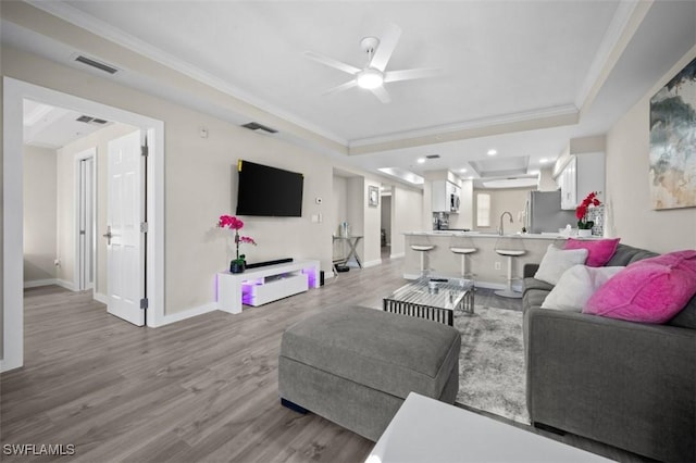 1793 Four Mile Cove Pkwy Unit 723, Cape Coral, FL 33990 - living room with crown molding, a raised ceiling, light wood-style flooring, ceiling fan, and baseboards