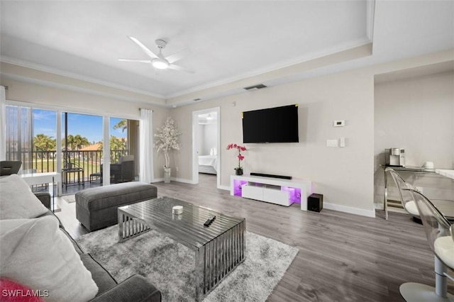1793 Four Mile Cove Pkwy Unit 723, Cape Coral, FL 33990 - living area featuring ceiling fan, baseboards, wood finished floors, ornamental molding, and a tray ceiling