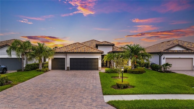 19197 Elston Way, Estero, FL 33928 - mediterranean / spanish home featuring a tiled roof, a garage, decorative driveway, and stucco siding