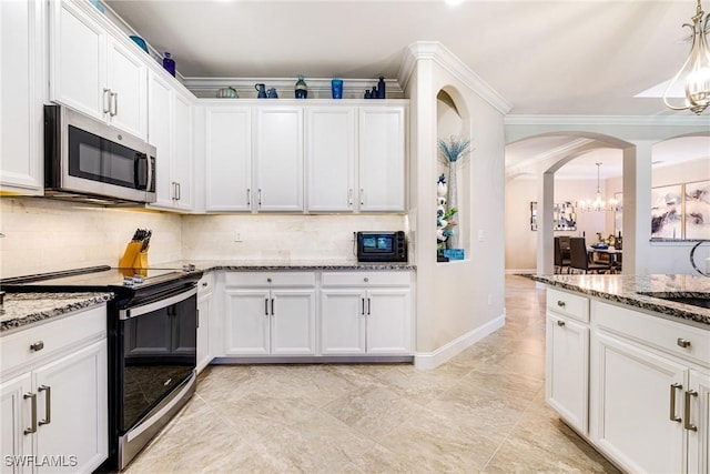 19197 Elston Way, Estero, FL 33928 - kitchen featuring appliances with stainless steel finishes, a chandelier, arched walkways, backsplash, and white cabinetry