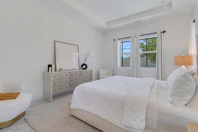 3652 Sapphire Cove Cir, Naples, FL 34114 - bedroom with a tray ceiling and light wood-style flooring