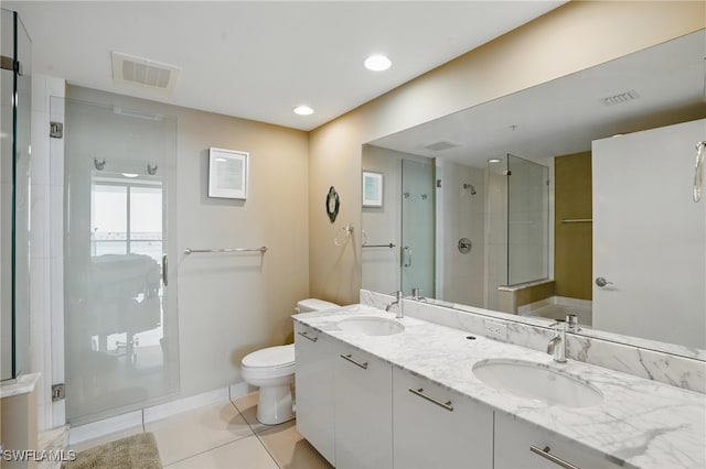 full bath featuring a stall shower, toilet, tile patterned flooring, baseboards, and double vanity