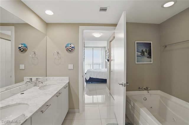 full bathroom featuring tile patterned flooring, a tub with jets, baseboards, double vanity, and connected bathroom