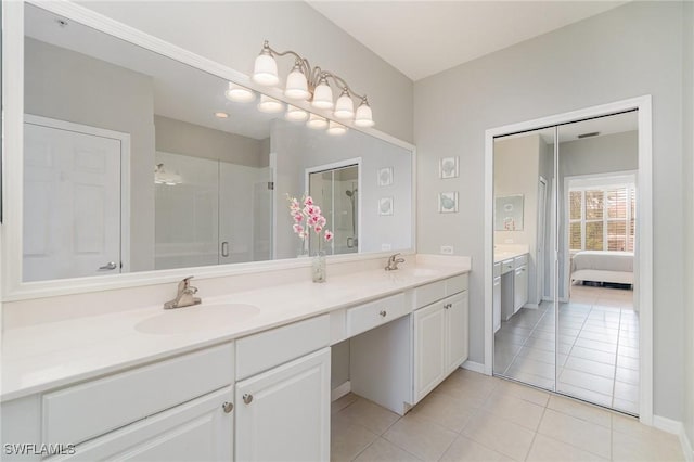 1430 Tiffany Ln Unit 2701, Naples, FL 34105 - ensuite bathroom with double vanity, a stall shower, tile patterned floors, and baseboards
