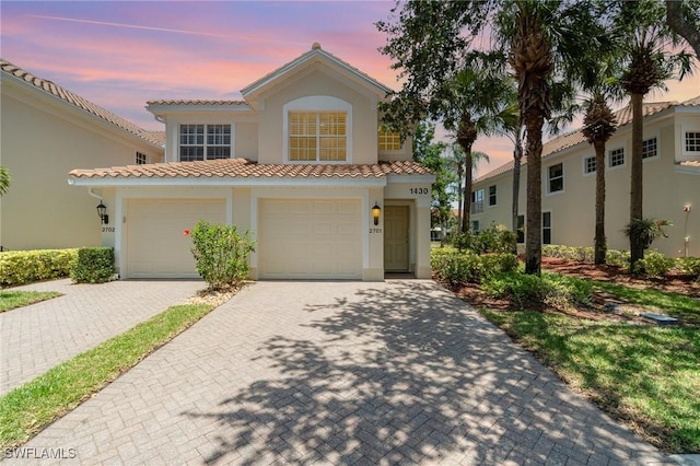 1430 Tiffany Ln Unit 2701, Naples, FL 34105 - mediterranean / spanish home with stucco siding, decorative driveway, a tiled roof, and an attached garage